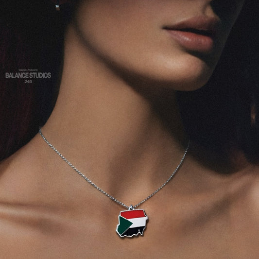 Necklace with a flag pendant worn by a person against a dark background